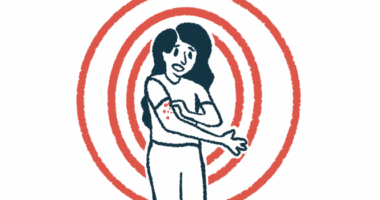 A woman scratches a rash on her arm.